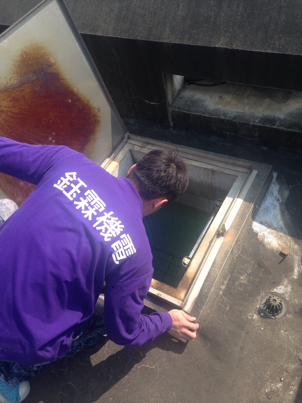 工程人員打開屋頂水塔蓋，檢查儲水池設備及水質狀況