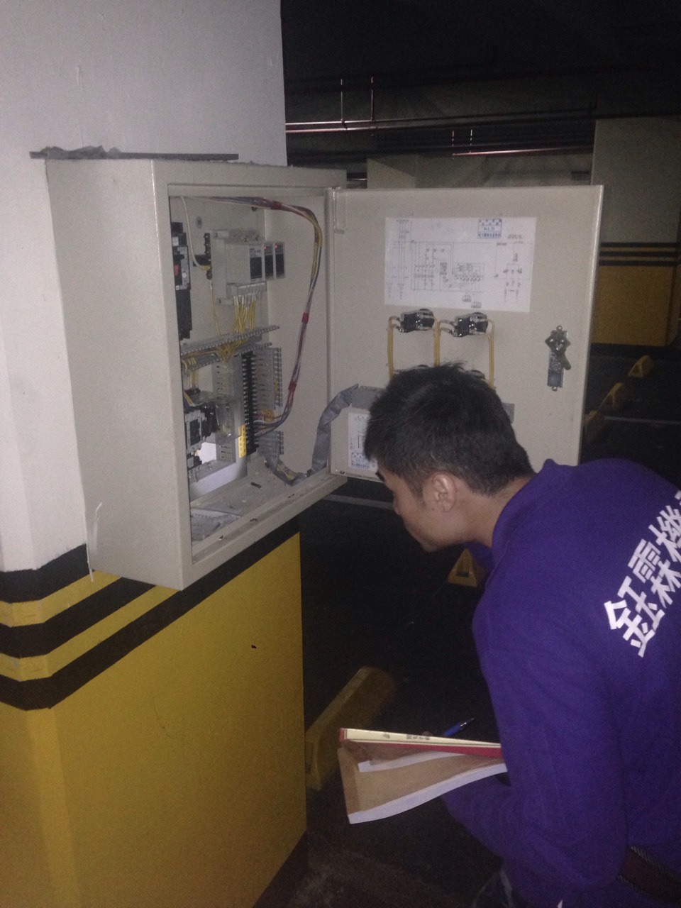 工程人員檢查停車場自動控制箱，確認電路設備運作正常