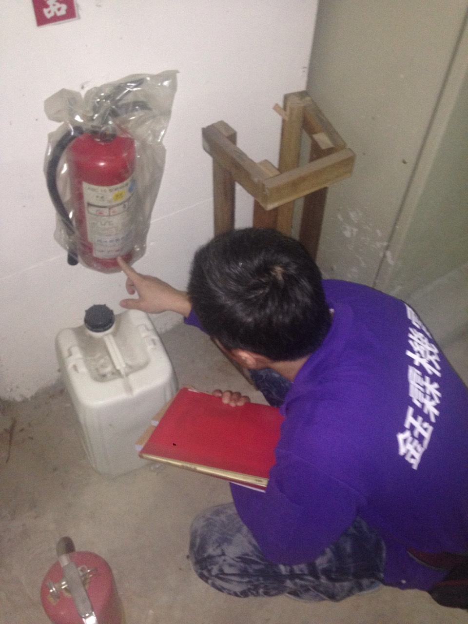 工程人員檢查滅火器效期，執行消防設備巡檢作業