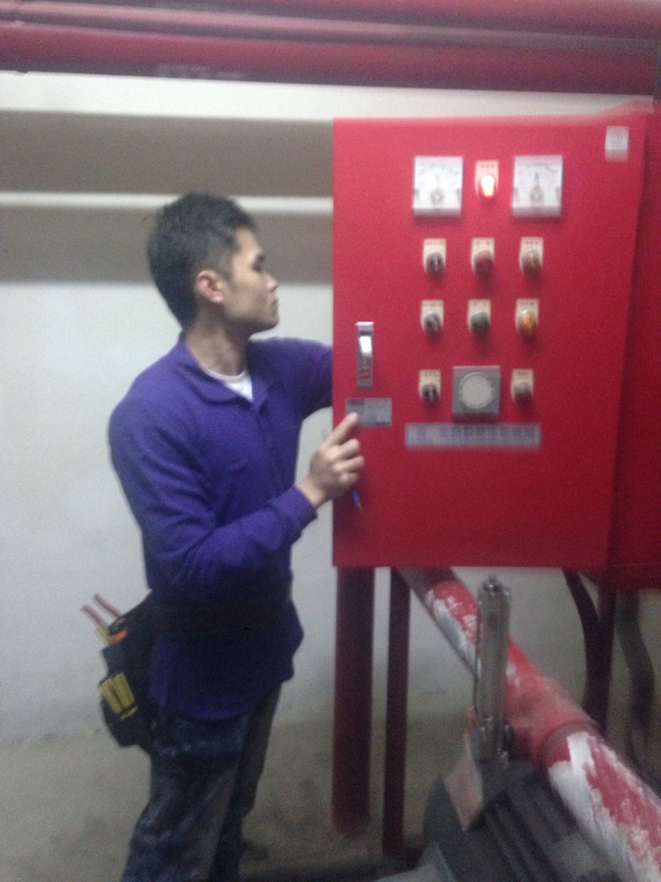 工程師檢查消防控制面板，進行消防安全系統設備日常維護