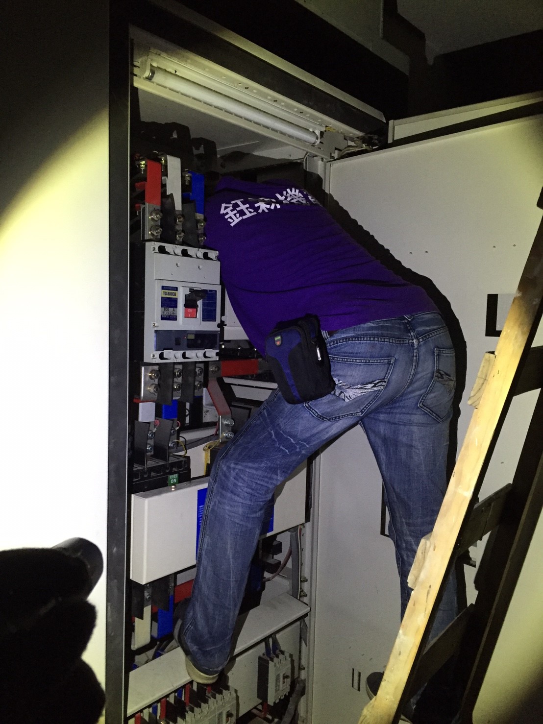電氣技師進入配電箱內部進行高壓電路維修